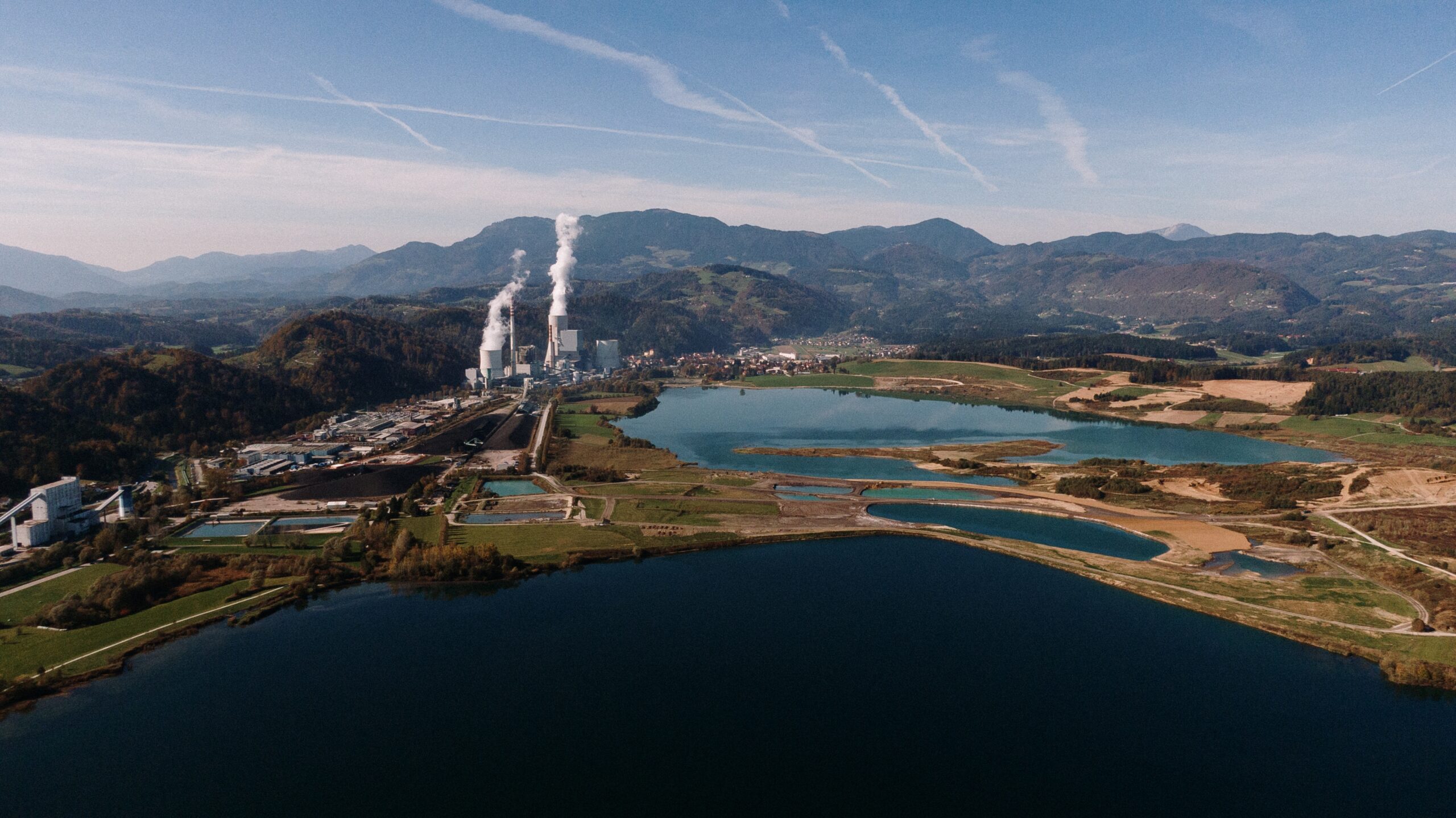 An aerial shot of a landscape surrounded by mountains and lakes with industrial disaster
